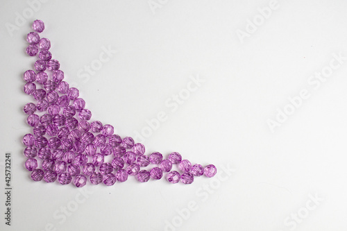 purple plastic beads on a white, gray background.