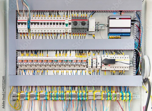 Electrical switchboard with different colored wires, switches and sensors photo