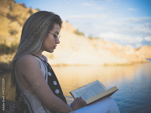 woman reading a book on the beach