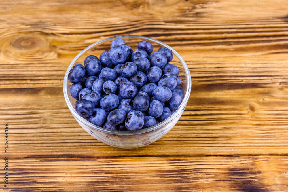 Blueberry in glass bowl on a wooden table Blueberry in glass bowl on a wooden table