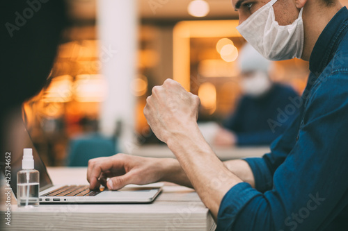 close up. freelancer in a protective mask works on a laptop