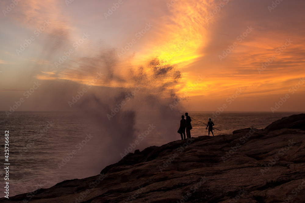 Water aerosol spraying in the air after Powerful waves hitting rocks at sunset, India