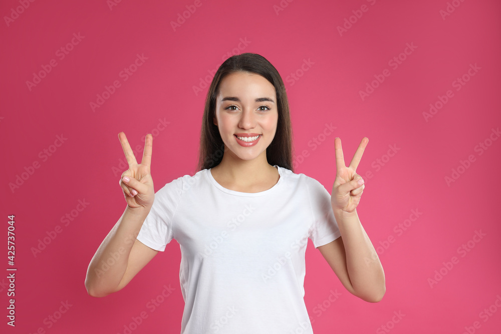 Woman showing number four with her hands on pink background Woman showing number four with her hands on pink background