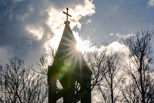 Foto dark clouds are gathering and cover the sun which is just shining above a church