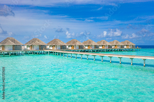 Travel landscape of Maldives beach. Tropical panorama, luxury water villa resort, wooden pier or jetty. Ocean lagoon, seaside. Luxury travel destination background for summer holiday vacation concept. © icemanphotos