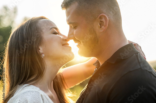 Couple lovers hugging and kissing in the park at sunset. Love, youth, happiness concept. © Andrii IURLOV