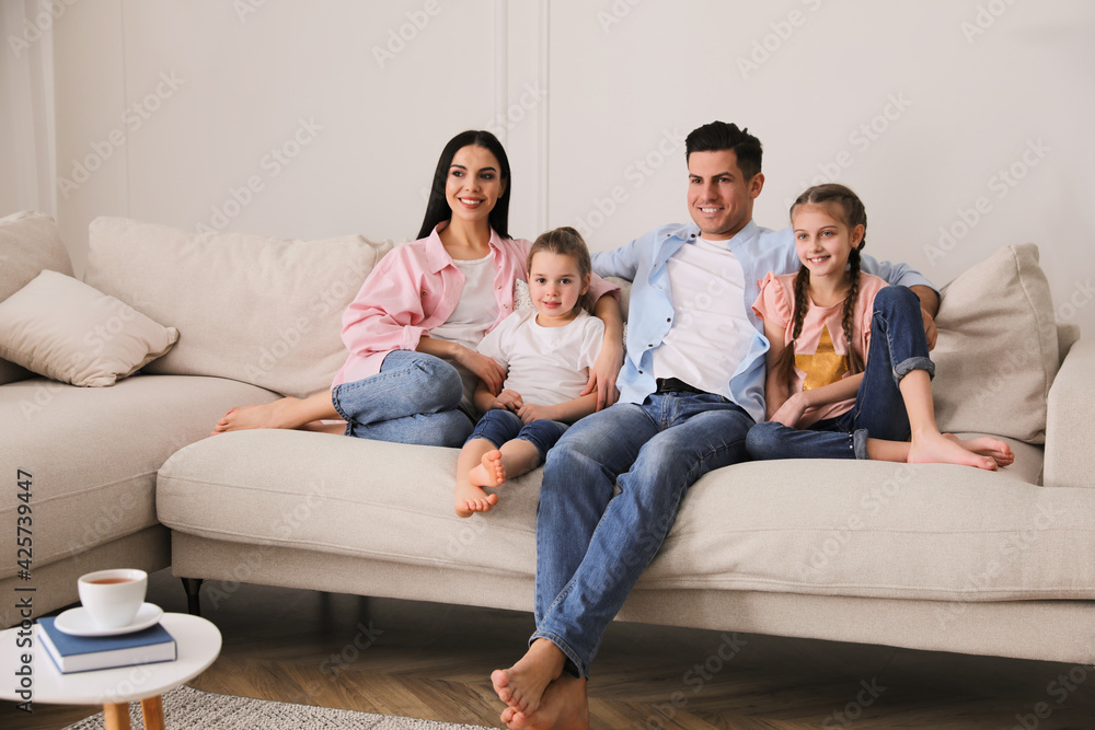 Happy family resting on comfortable sofa in living room Happy family resting on comfortable sofa in living room