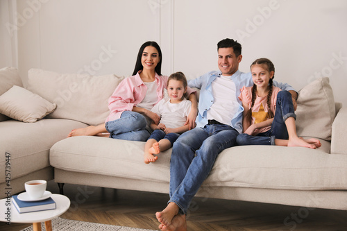 Happy family resting on comfortable sofa in living room