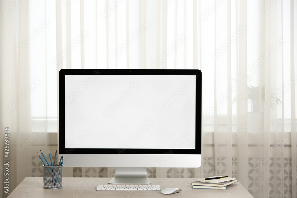 Modern computer with blank screen and stationery on table indoors. Space for design Modern computer with blank screen and stationery on table indoors. Space for design