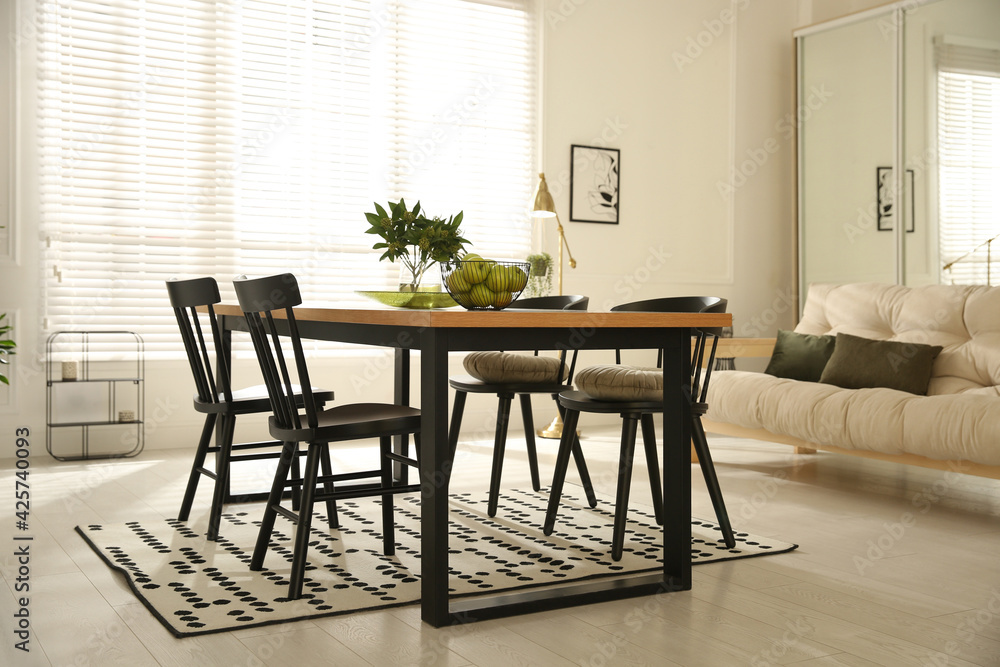 Fototapeta premium Stylish wooden dining table and chairs in room. Interior design