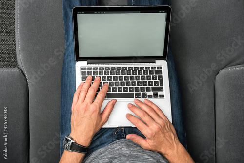 Slika na platnu Mann mit Laptop auf Sofa. (Vogelperspektive)