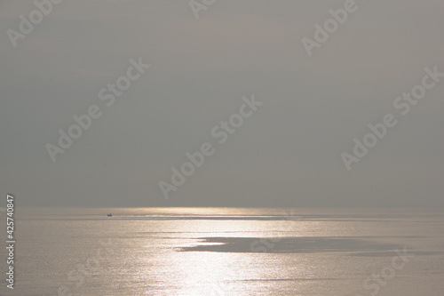 Beautiful sunset and silver trail on the sea on a gray sky background © Natalia