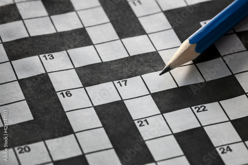 Obraz na plátně Solving a crossword puzzle with blue pencil