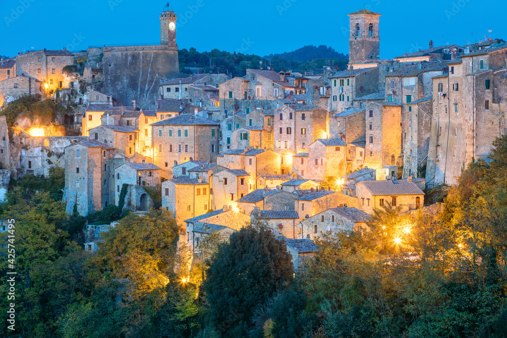 View of Sorano town in the evening night with old tradition buildings and illumination. Tuscany, Italy