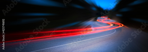 Panoramic - Cars light trails at night in a curve road