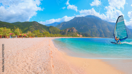 Fototapeta Naklejka Na Ścianę i Meble -  Beautiful cloudy sky with Windsurfer Surfing The Wind On Waves - Panoramic view of Oludeniz Beach And Blue Lagoon, Oludeniz beach is best beaches in Turkey - Fethiye, Turkey