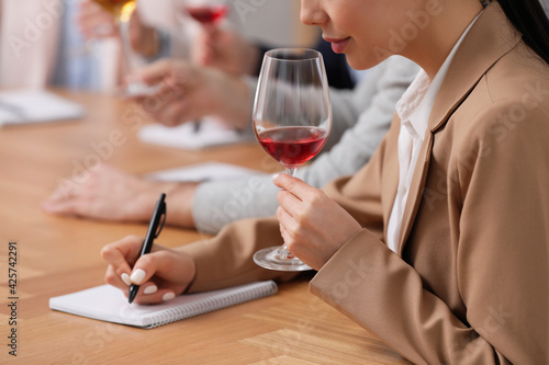 Sommeliers tasting different sorts of wine at table indoors  closeup