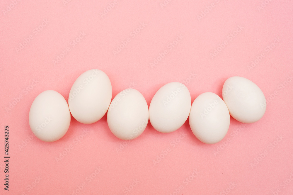 White chicken eggs on pink background White chicken eggs on pink background