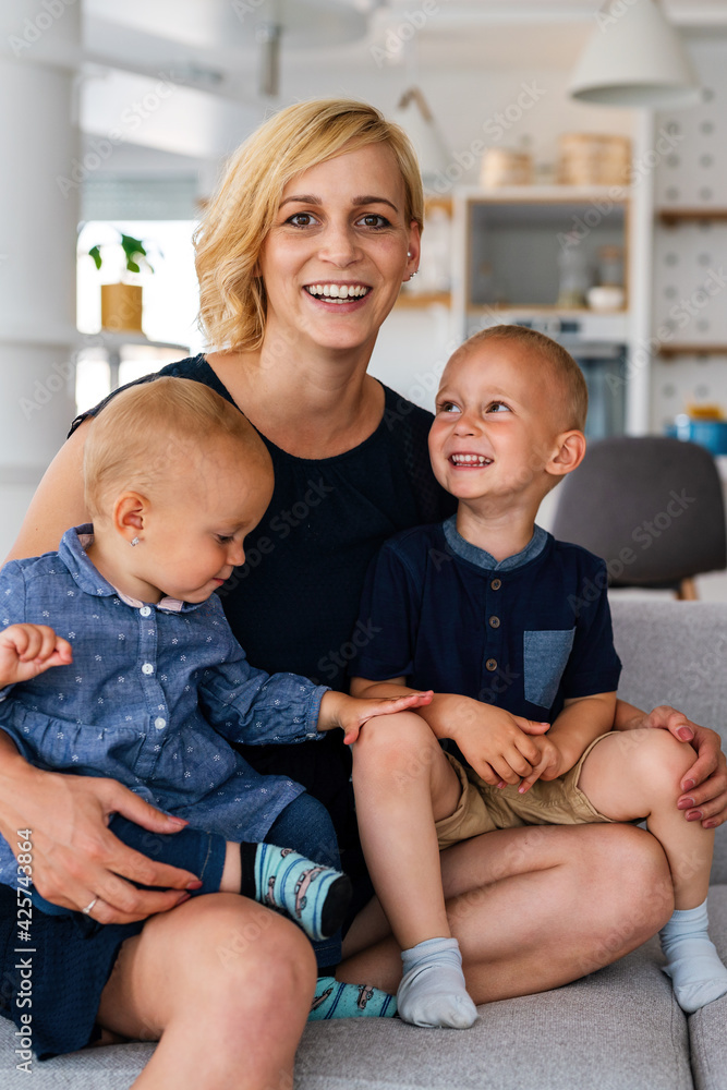 Portrait of beautiful young mother smiling happily, embracing her children Portrait of beautiful young mother smiling happily, embracing her children