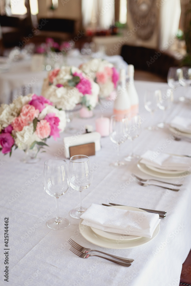 Wedding ceremony decoration in the restaurant. Decoration of wedding table with tender pink textile Wedding ceremony decoration in the restaurant. Decoration of wedding table with tender pink textile