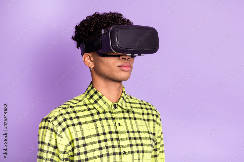 Photo portrait of guy wearing virtual reality glasses serious in checkered shirt isolated on pastel violet color background Photo portrait of guy wearing virtual reality glasses serious in checkered shirt isolated on pastel violet color background