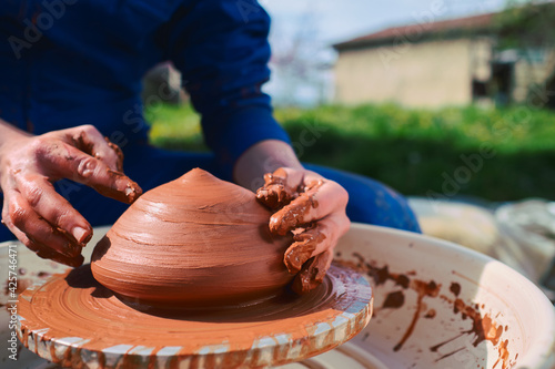 Billede på lærred Young woman artist making clay bowl on pottery wheel