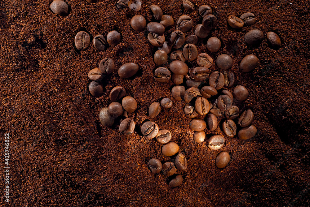 Coffee beans close up. Texture of ground and grain coffee. Contrasting dramatic light as an artistic effect. Coffee beans close up. Texture of ground and grain coffee. Contrasting dramatic light as an artistic effect.