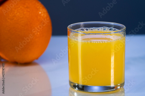 Glass of orange juice and orange fruit isolated on beautiful background. Close up shot