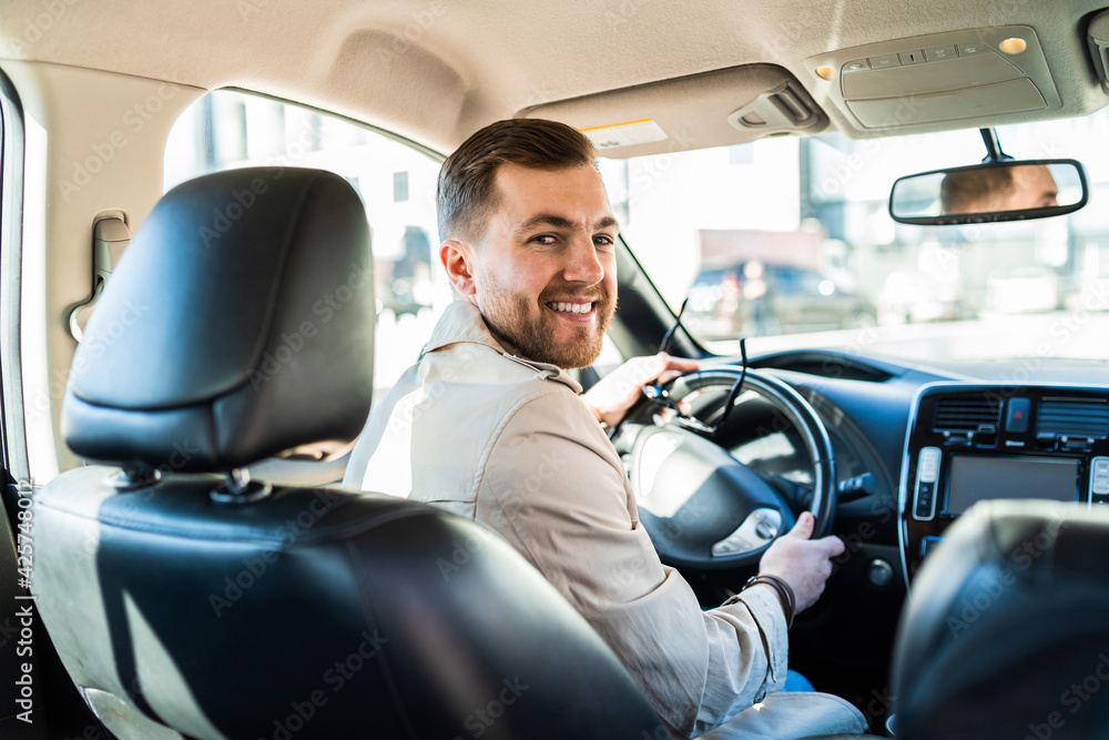 Handsome male driver looking back Handsome male driver looking back