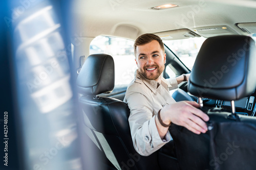 Foto Smiling man driving in reverse on car