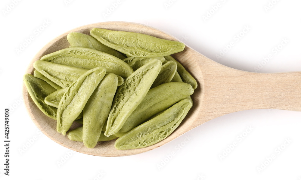 Dried durum pasta with spinach (foglie d'ulivo) in olive leaf shape with wooden spoon isolated on white background, top view Dried durum pasta with spinach (foglie d'ulivo) in olive leaf shape with wooden spoon isolated on white background, top view