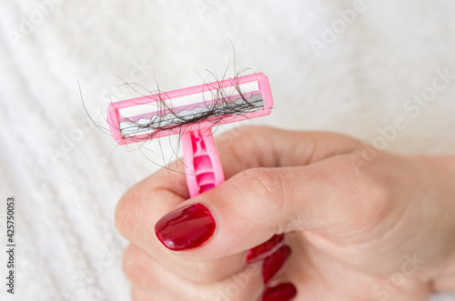 Women's shaving razor with shaved off unwanted pubic hairs