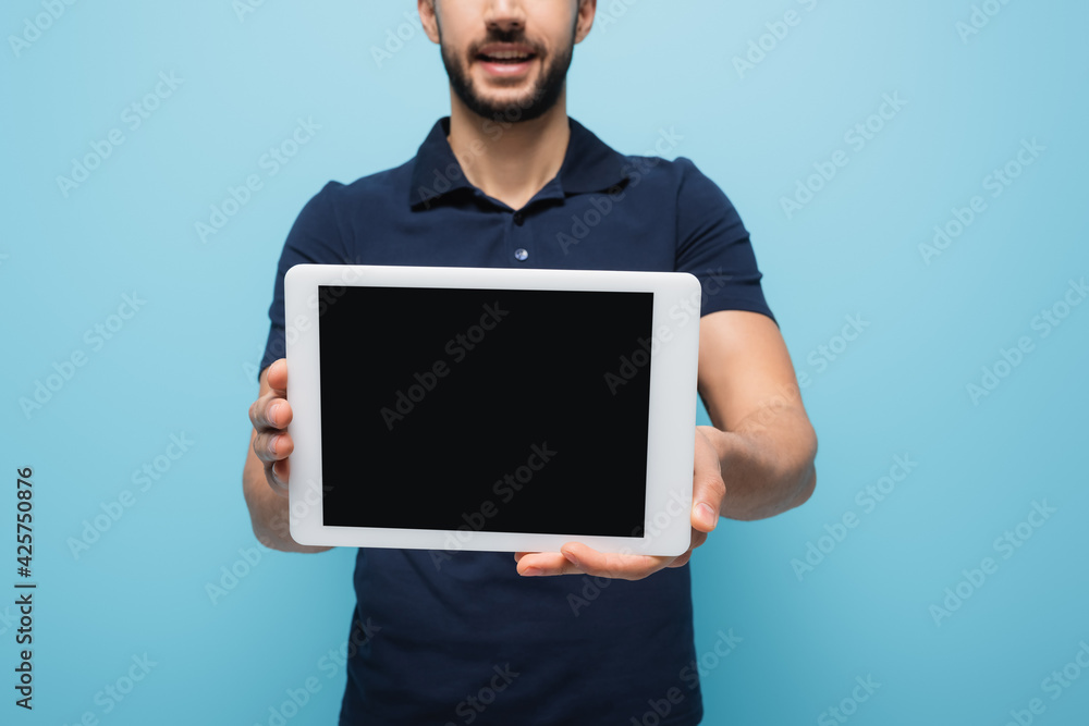 cropped view of delivery man showing digital tablet with blank screen isolated on blue, blurred background cropped view of delivery man showing digital tablet with blank screen isolated on blue, blurred background