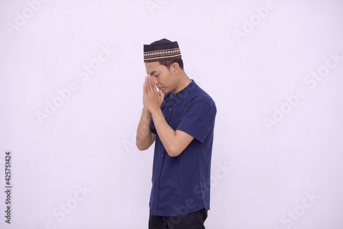 young asian muslim praying to the God isolated white background photo