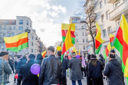 Demonstration about the kurdish freedom moovement at the birthday of Öcalan in Berlin. Demonstrating people hold banners and posters in the air.