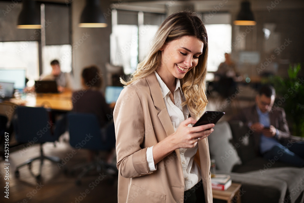© JustLife - Businesswoman in office. Smiling businesswoman using the phone in office. © JustLife - Businesswoman in office. Smiling businesswoman using the phone in office.
