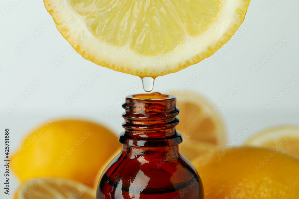 Lemon with drop of juice over the bottle, close up Lemon with drop of juice over the bottle, close up