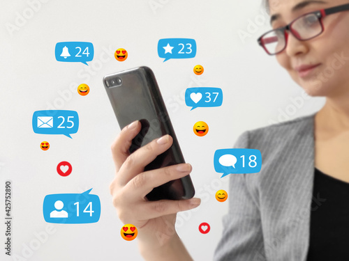Social media concept, businesswoman holding smartphone with social network icons
