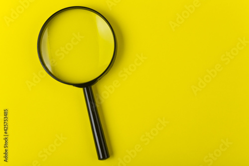 Magnifying glass on a yellow background close-up.Detail for design.