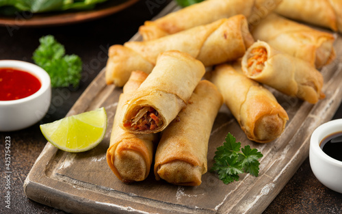 Fototapeta Fried vegetable spring rolls with sweet chili and soya sauce on wooden board