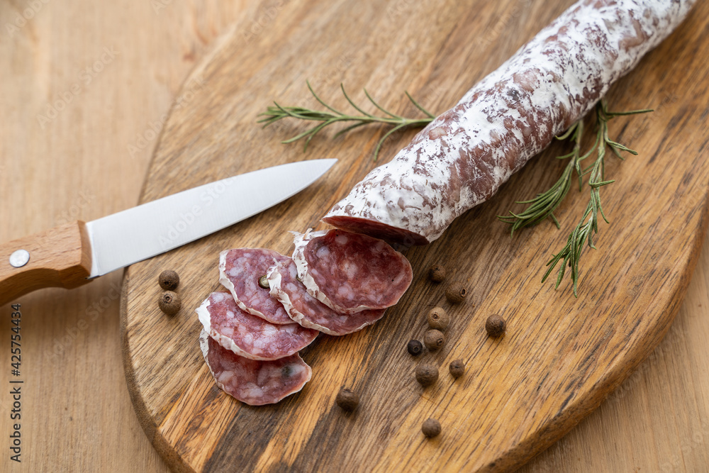 Raw smoked sausage cut into pieces and a knife on a wooden cutting board Raw smoked sausage cut into pieces and a knife on a wooden cutting board