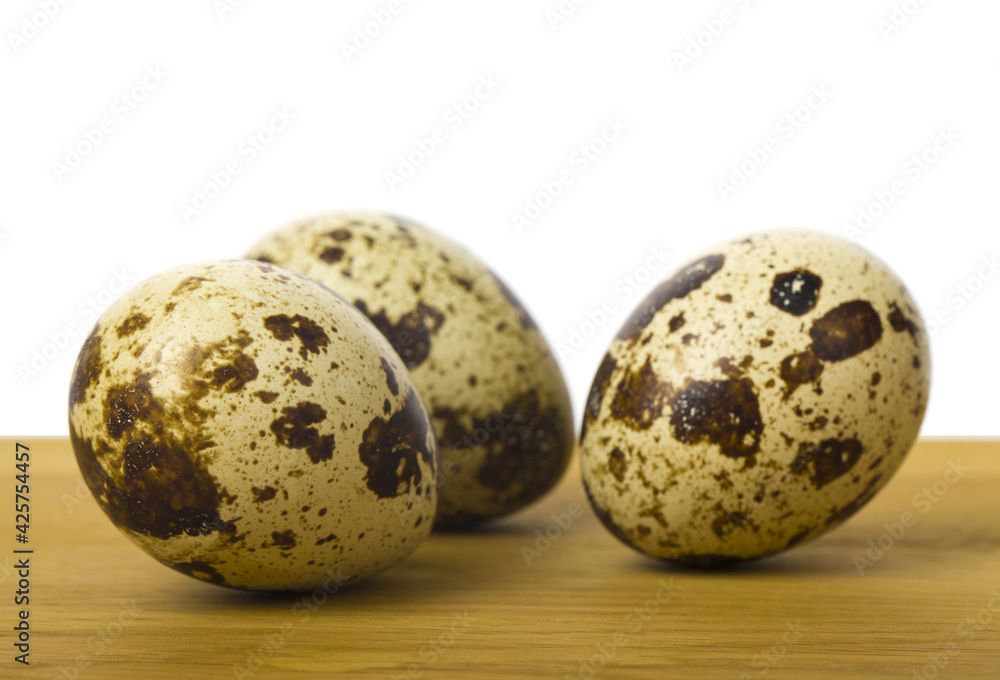 Quail eggs on a wooden table close-up.