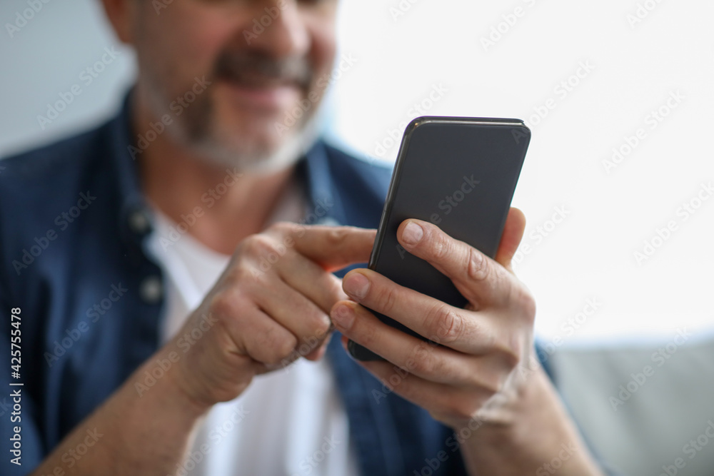 Unrecognizable matured man using modern mobile phone