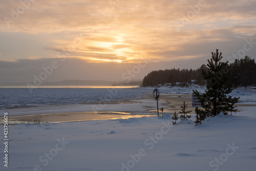 Snowy and icy beach with a sunset in Sweden