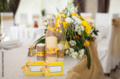 Decoration of wedding table. Yellow and beige colors. Wedding champagne, candles, flowers photo