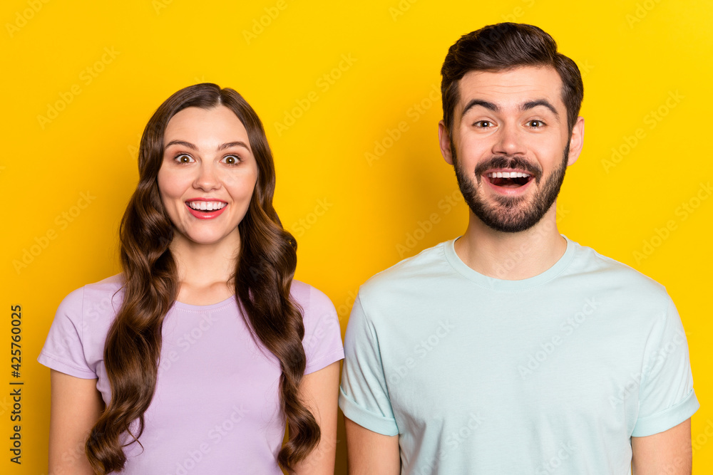 Portrait of attractive amazed cheerful couple having fun good mood isolated over bright yellow color background Portrait of attractive amazed cheerful couple having fun good mood isolated over bright yellow color background