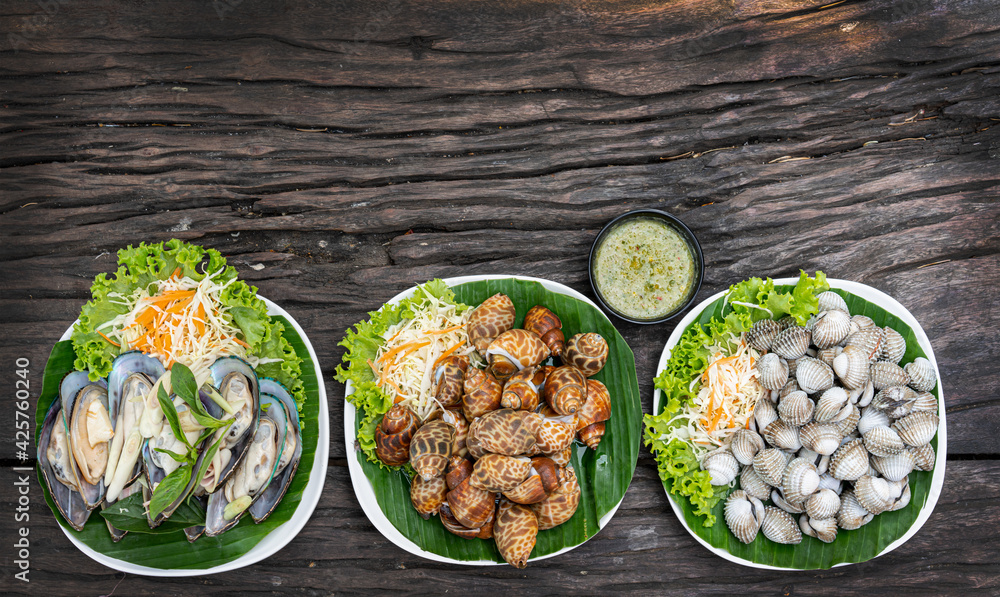 Seafood on a plate and ready to serve on wooden table Seafood on a plate and ready to serve on wooden table