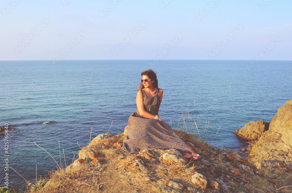Beautiful Young Woman with Dress on a Sunset Sea  Background 