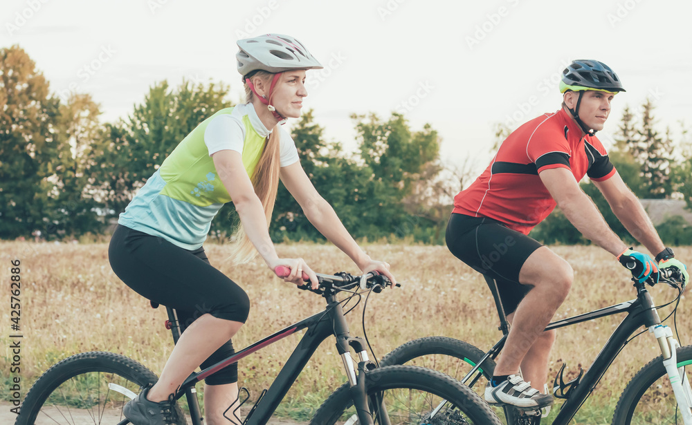 
couple ride bicycles in the summer at the stadium