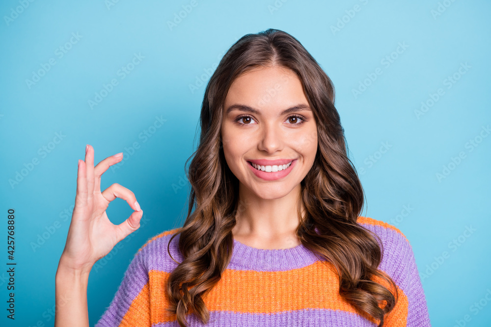 Photo of gorgeous beautiful young woman make okay sign approve nice isolated on blue color background Photo of gorgeous beautiful young woman make okay sign approve nice isolated on blue color background